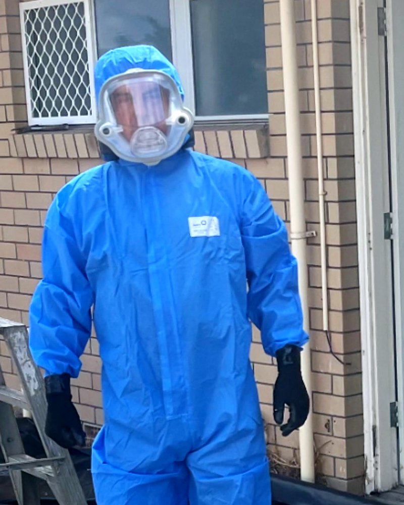 CleanSlate Asbestos WA worker in disposable coveralls wearing an AYO WX FFM-LF full-face powered respirator on an asbestos removal site